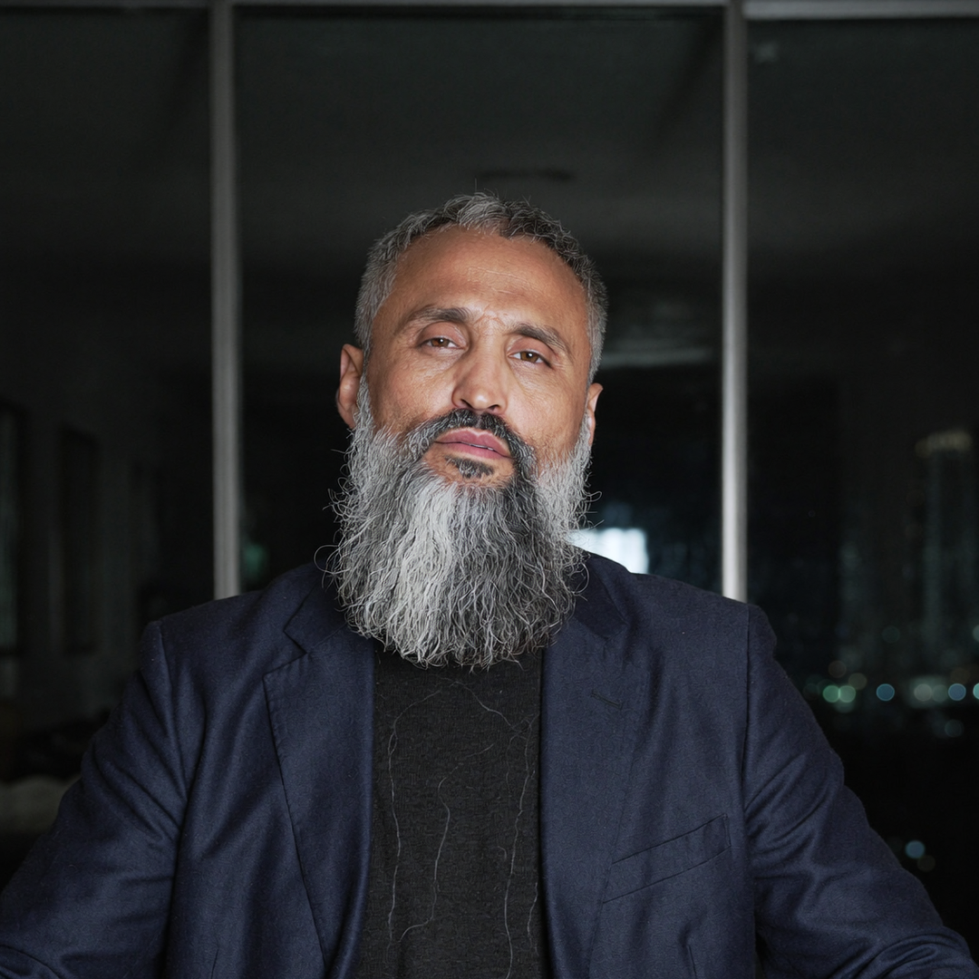 Gennady MC, founder of Anonymous Media, in a dark suit by a night window